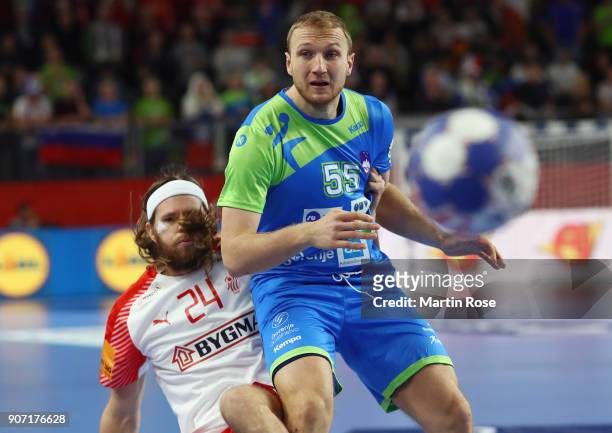 Ziga Mlakar of Slovenia is challenged by Mikkel Hansen of Denmark during the Men's Handball European Championship main round group 2 match between...