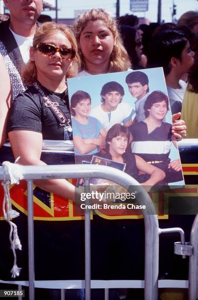 Beverly Hills, CA. A fan holds up a Menudo poster outside The Wherehouse music store where ex-Menudo member, Ricky Martin performed. Photo by Brenda...