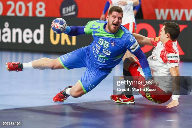 Matic Suholeznik of Slovenia is challenged by Rasmus Lauge Schmidt of Denmark during the Men's Handball European Championship main round group 2...