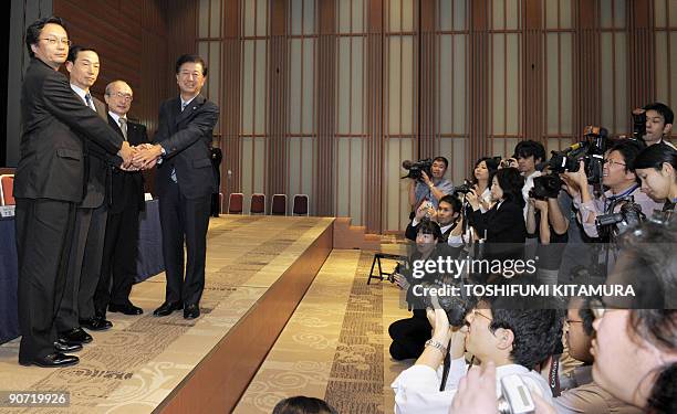 Members of the media take photos as Casio Hitachi Mobile Communications president Takeki Oishi , NEC Corp. Executive director Akihito Otake , Casio...