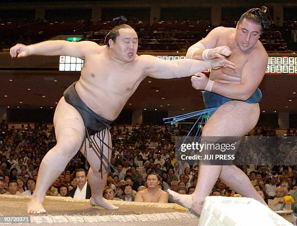 Mongolian sumo grand champion Asashoryu pushes Tochinoshin of Georgia out of the ring during the second day of the 15-day Autumn Grand Sumo...