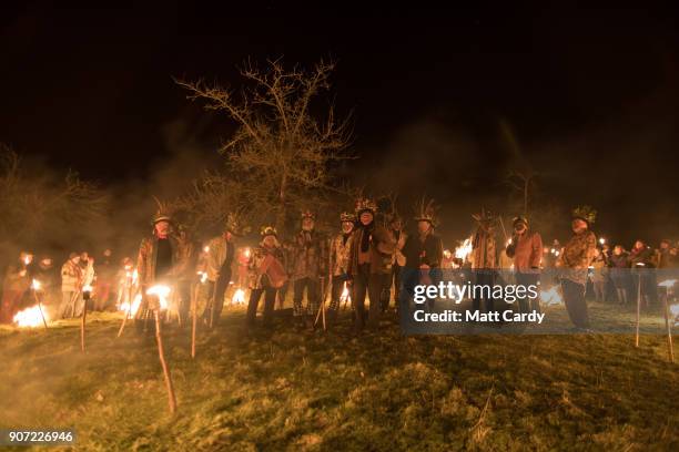 Members of the Leominster Morris are watched by members of the public who have gathered in a apple orchard to take part in a torchlit Oldfields...