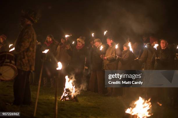 Members of the Leominster Morris are watched by members of the public who have gathered in a apple orchard to take part in a torchlit Oldfields...