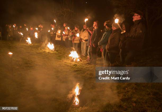 Members of the Leominster Morris are watched by members of the public who have gathered in a apple orchard to take part in a torchlit Oldfields...