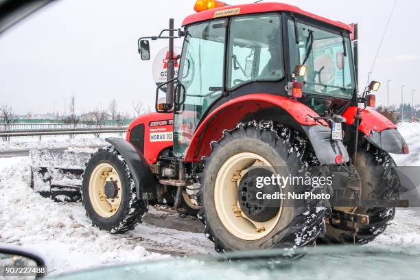 Worker in the Zetor 7341 tractor snow-clearing parking lot in front of the shopping center is seen in Gdansk, Poland on 19 January 2018 Heavy snow...