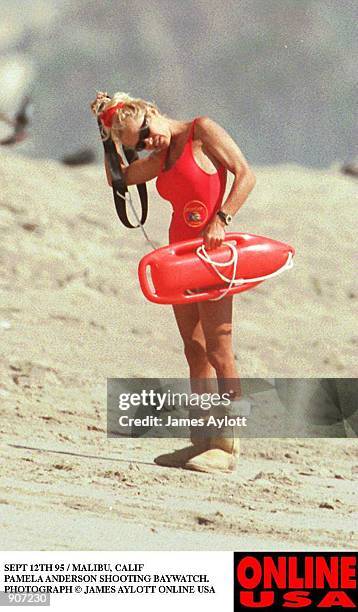 SEPT 12TH 95 HOLLYWOOD CALIF PAMELA ANDERSON SHOOTING BAYWATCH. SHE WEARS HER WINTER BOOTS ON THE HOT BEACH