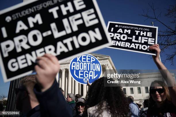 Pro-life activists try to block the sign of a pro-choice activist during the 2018 March for Life January 19, 2018 in Washington, DC. Activists...