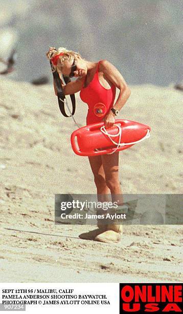 SEPT 12TH 95 HOLLYWOOD CALIF PAMELA ANDERSON SHOOTING BAYWATCH. SHE WEARS HER WINTER UGH BOOTS ON THE HOT BEACH