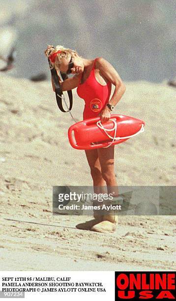 SEPT 12TH 95 HOLLYWOOD CALIF PAMELA ANDERSON SHOOTING BAYWATCH. SHE WEARS HER WINTER UGH BOOTS ON THE HOT BEACH