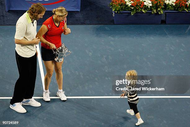 Kim Clijsters of Belgium with the championship trophy alongside husband Brian Lynch and daughter Jada after defeating Caroline Wozniacki of Denmark...