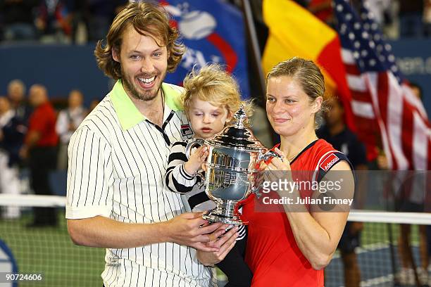 Kim Clijsters of Belgium poses with the championship trophy alongside husband Brian Lynch and daughter Jada after defeating Caroline Wozniacki of...
