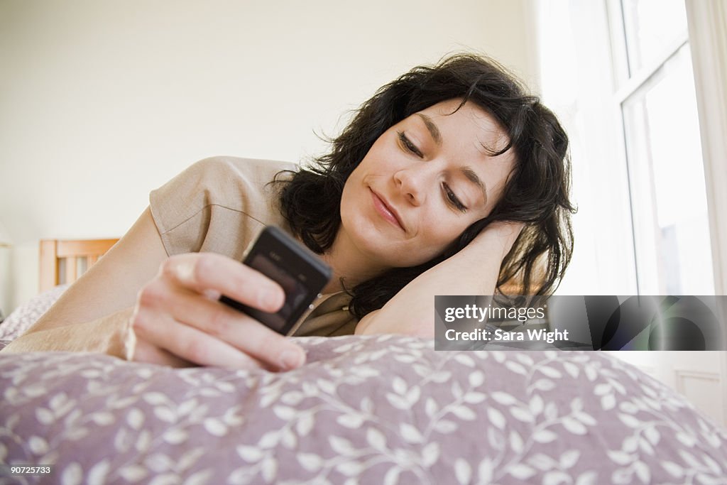 Woman Texting While Lying on Bed