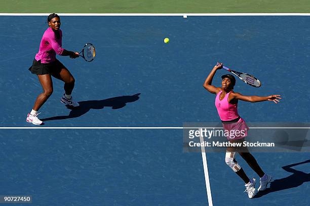 Venus Williams and Serena Williams return a shot against Cara Black of Zimbabwe and Liezel Huber during the Women's Doubles final on day fifteen of...