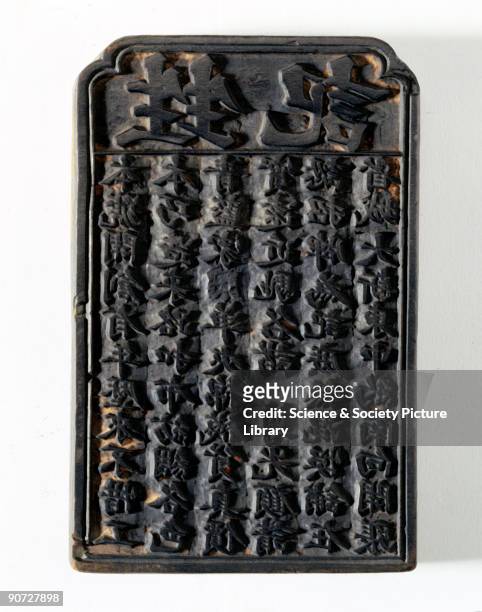 Patterns and symbols carved into the surface of wooden blocks like this were used to print not only fabrics but also sacred charms. Japanese writing...