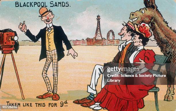 Comic postcard showing a comic photographer taking a group portrait on Blackpool beach. The couple being photographed, and a donkey, all smile for...