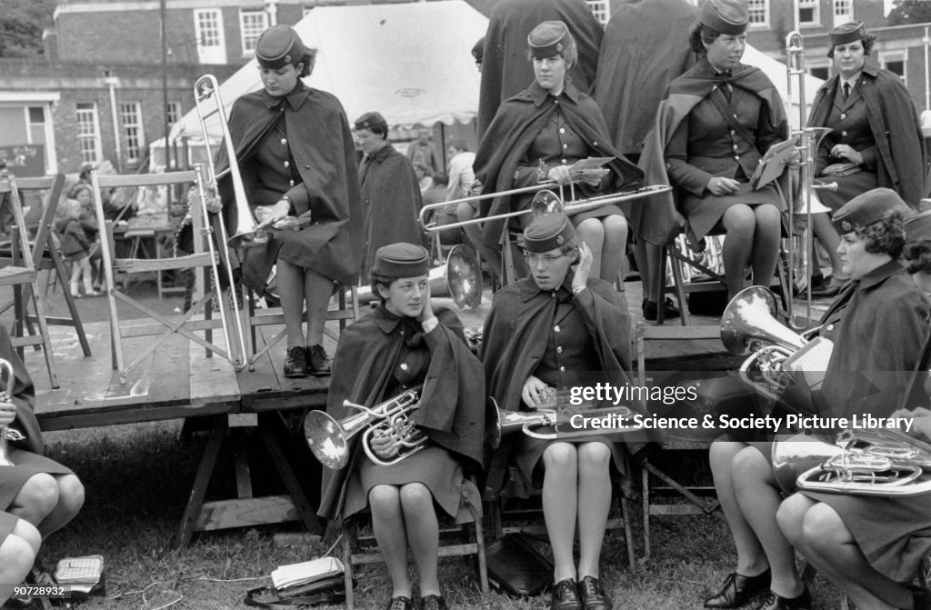 Band of women musicians in uniform, preparing to play at a festival, 1969.