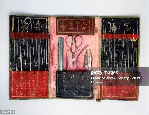 Steel surgical instruments in a folding leather case decorated with Chinese characters. Chinese medicine is based on ancient texts that relate...