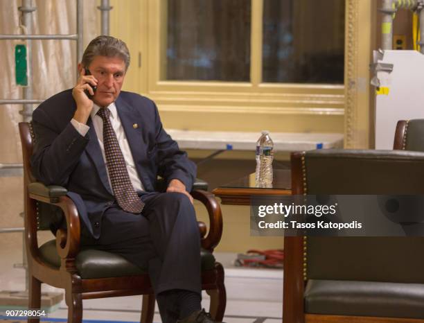 Senator Joe Manchin takes a call before a Democratic Caucus meeting at the US Capitol on January 19, 2018 in Washington, DC. A continuing resolution...