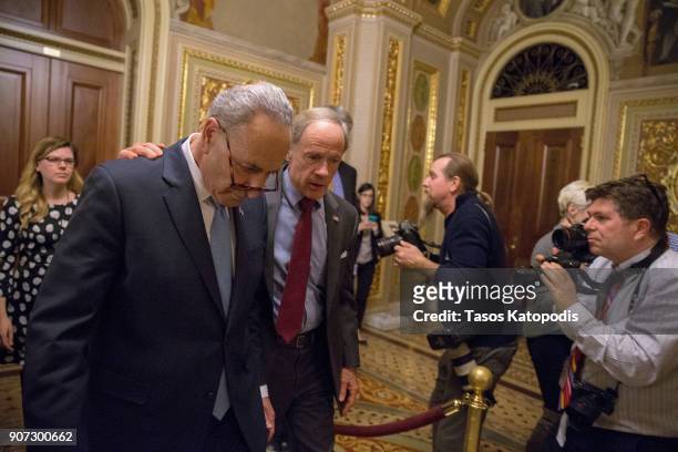 Senate Minority Leader Chuck Schumer and Senator Tom Carper walk out of a Democratic Caucus meeting at the US Capitol on January 19, 2018 in...
