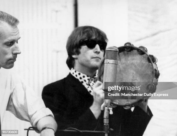 Caption reads: 'John on tambourine. Beatle recording sessions, mainspring of success, are strictly private'. John Lennon formed the Beatles in 1960...