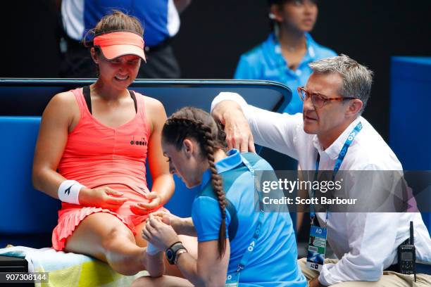 Lauren Davis of the United States receives medical treatment after injuring her foot in a fall in her third round match against Simona Halep of...