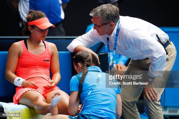 Lauren Davis of the United States receives medical treatment after injuring her foot in a fall in her third round match against Simona Halep of...