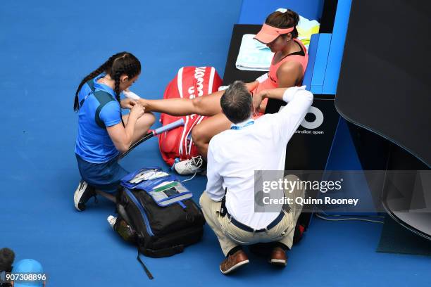 Lauren Davis of the United States receives medical treatment after injuring her foot in a fall in her third round match against Simona Halep of...