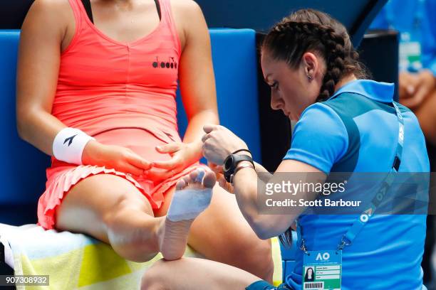 Lauren Davis of the United States receives medical treatment after injuring her foot in a fall in her third round match against Simona Halep of...