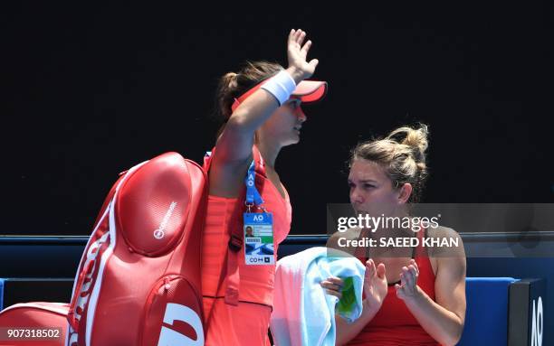 Defeated Lauren Davis of the US acknowledges spectators while Romania's Simona Halep applauds on the bench in their women's singles third round match...