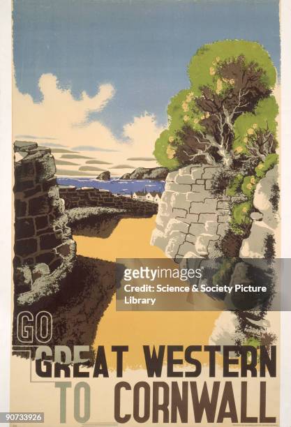 Poster produced for the Great Western Railway to promote rail travel to Cornwall. The poster shows a view of a sandy path lined with stone walls...