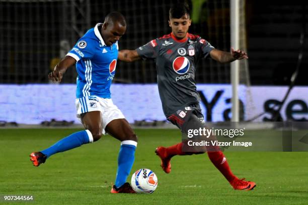 Jair Palacios of Millonarios passes the ball while defended by Kevin Ramirez of America de Cali during the friendly match between Millonarios and...