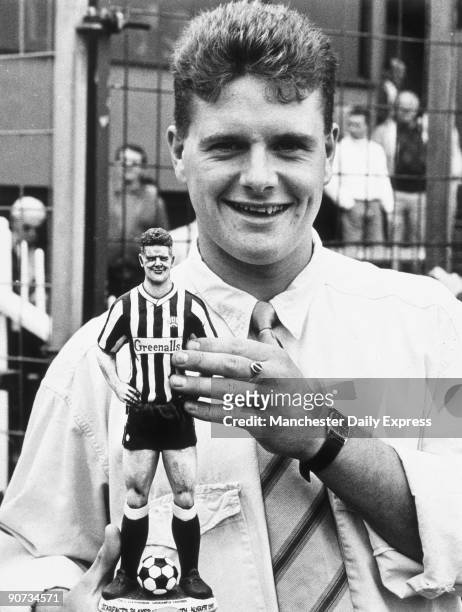 Paul Gascoigne holding a model of himself wearing a Newcastle United kit. Gascoigne joined Newcastle United in 1983, and subsequently played for...