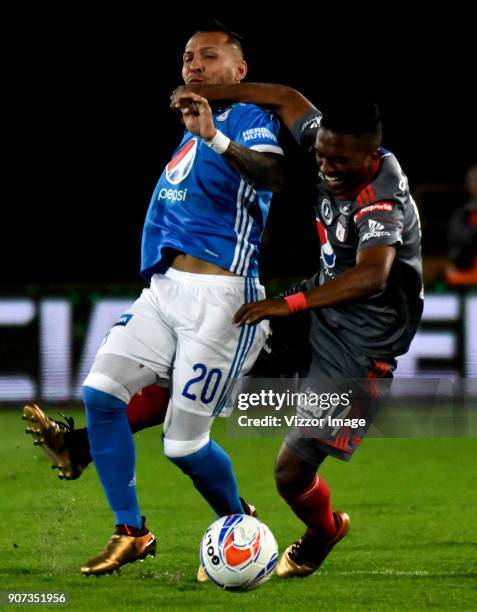 Juan Guillermo Dominguez of Millonarios vies for the ball with Ivan Velez of America de Cali during the friendly match between Millonarios and...