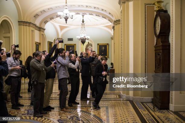 Members of media photograph the Ohio Clock as it strikes midnight outside the Senate Chamber at the Capitol Building in Washington, D.C., U.S., on...