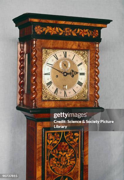 Detail of hood and dial. Made by Richard Baker of London, this is a typical example of an English long case clock in a marquetry case. The clock...