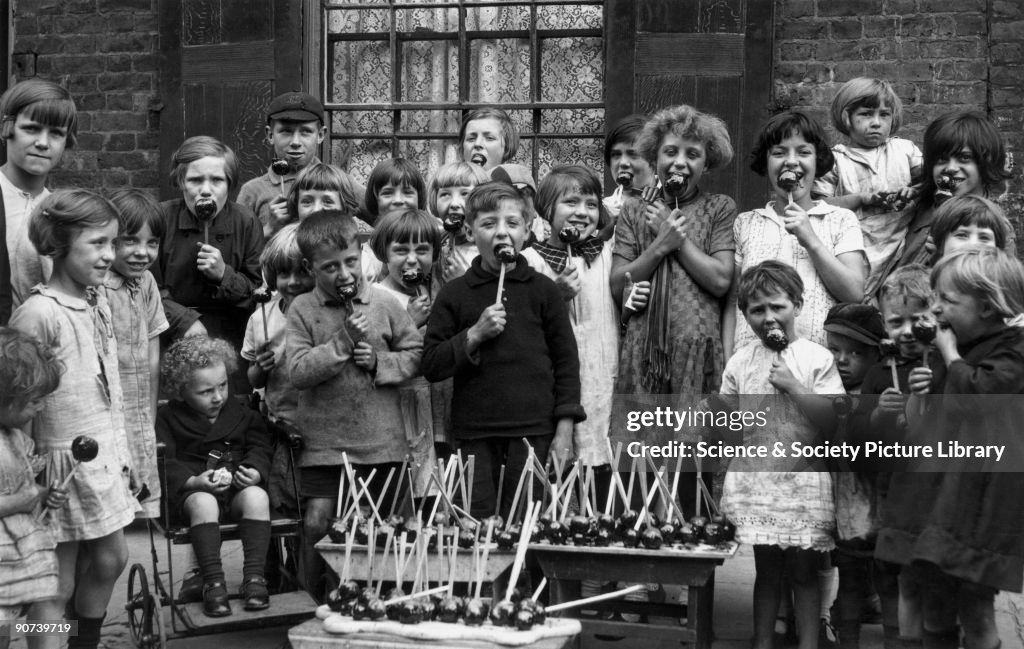 Children eating toffee apples, c 1930s.