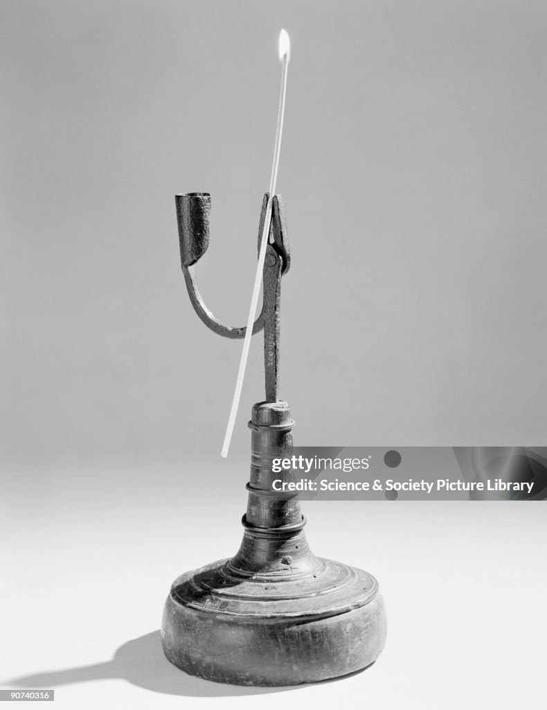 Candle holder with burning rushlight.
