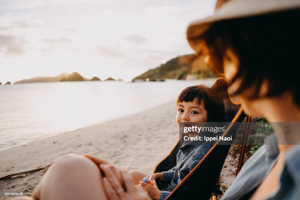 Cute mixed race toddler girl with mother on beach, Okinawa, Japan