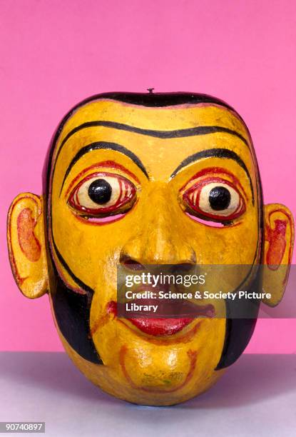 Polychrome wooden disease mask in the form of a human face, used for healing rituals. In some forms of traditional medicine, healing powers lie in...