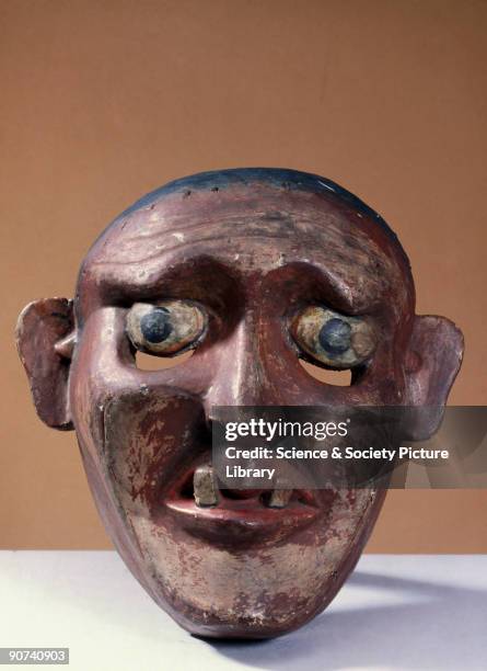 This wooden mask shows a brown-faced, gap-toothed, wrinkled man, possibly a peasant from the kolam masked play, and was worn for healing rituals. In...