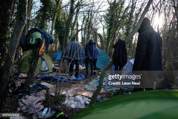 Group of young migrants stand near to their tents and shelters near an industrial estate on January 19, 2018 in Calais, France. During a visit to the...