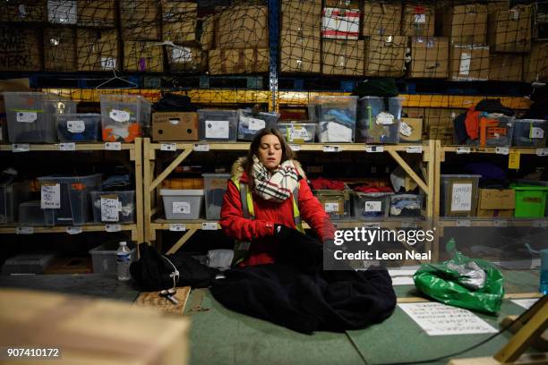 Donated clothes are sized and sorted at the "Help Refugees" charity warehouse on January 19, 2018 in Calais, France. During a visit to the UK by...