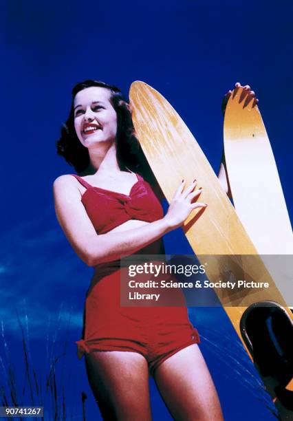 Kodachrome print showing a young woman in a bathing costume with a pair of water-skis. Kodachrome film, the first multi-layer colour film, was...