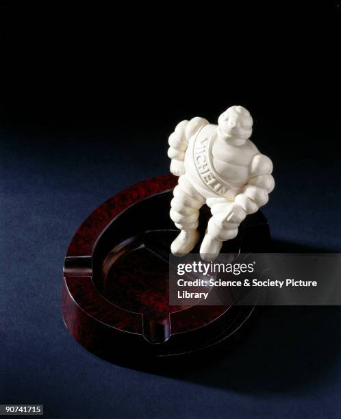 Made from walnut coloured Bakelite , it has a 'Michelin' man of ivory urea formaldehyde sitting on its edge and was made to promote Michelin tyres....