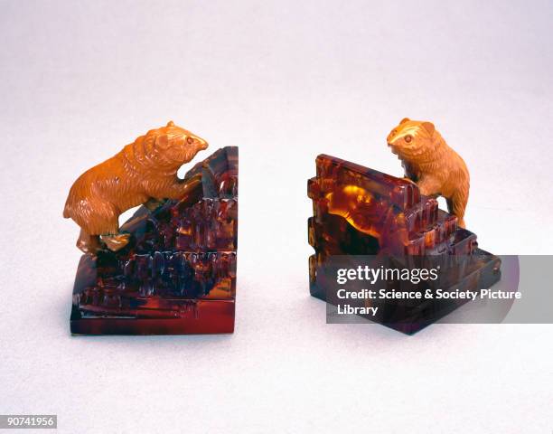 Cast book-ends of transparent amber cast phenolic, surmounted by bears of orange urea formaldehyde. By 1928, phenolic resins could be produced at...