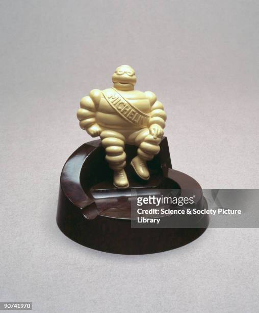 Made from walnut coloured Bakelite , it has a 'Michelin' man of ivory urea formaldehyde sitting on its edge and was made to promote Michelin tyres....