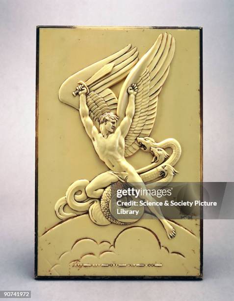 Made by De La Rue Plastics this is a rectangular plaque of cream urea formaldehyde, moulded with the figure of a naked male winged warrior. The...