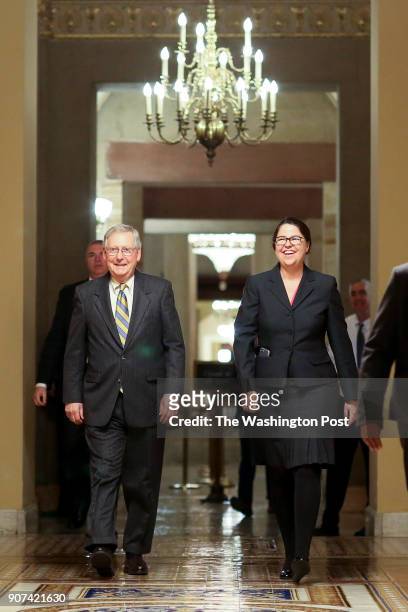 Senate Majority Leader Mitch McConnell, R-Ky., left, walks with Secretary for the Majority Laura Dove to the chamber on January 19, 2018 in...