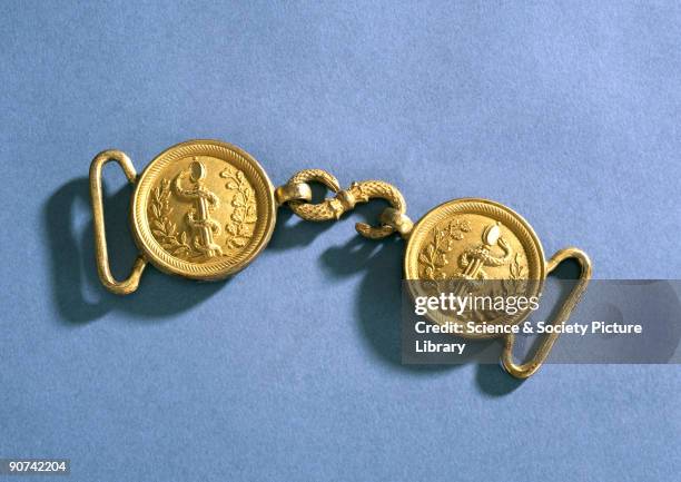 The buckle consists of two discs with an embossed caduceus and foliage, linked by a serpent made of ormolu. It is in the style worn by medical...
