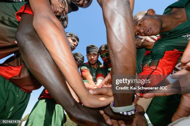 Sukhdeep Singh of Kenya and his team mates huddle prior to the ICC U19 Cricket World Cup match between the West Indies and Kenya at Lincoln Oval on...